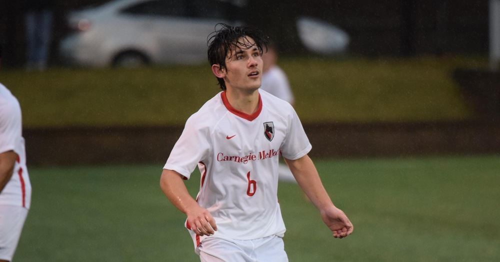 men's soccer player wearing all white waiting to receive a pass