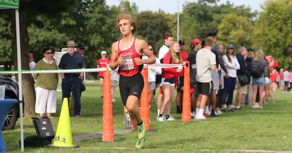 men's cross country runner crossing the finish line