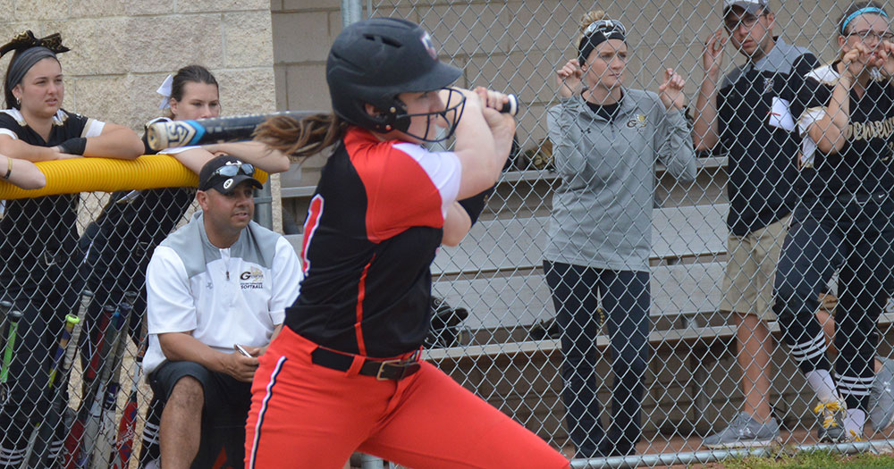 women's softball player swinging at a pitch