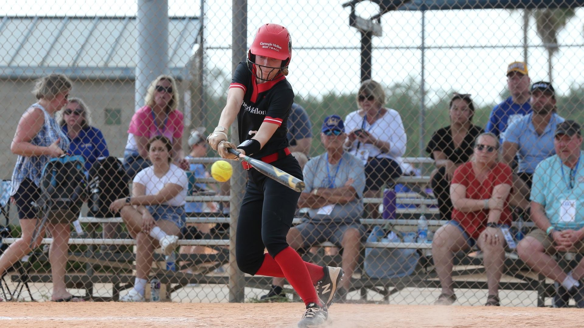 women's softball player batting left handed and batting the ball