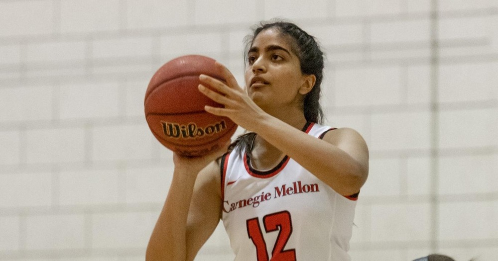 women's basketball player wearing white uniform about to take a shot