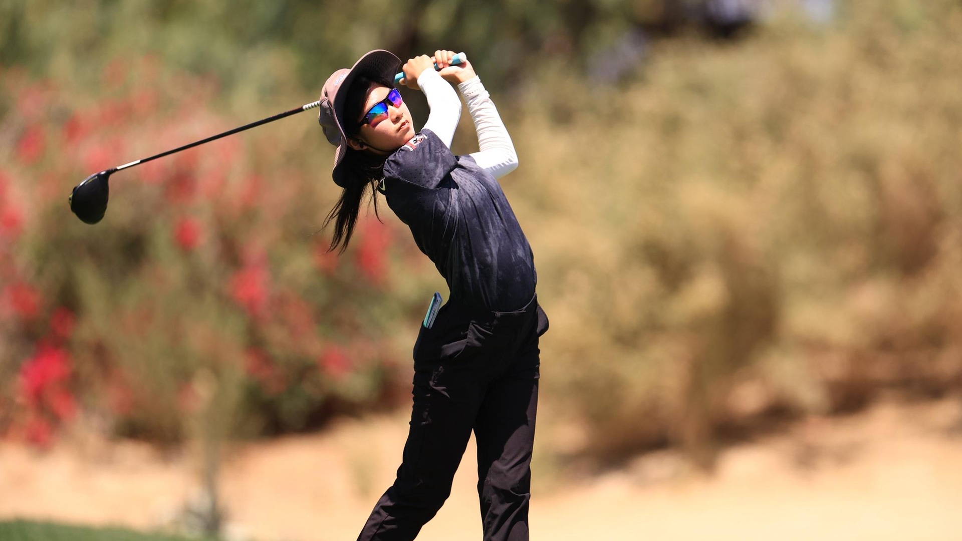 women's golfer starring down ball after striking it