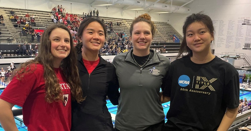 four women standing side by side with pool behind