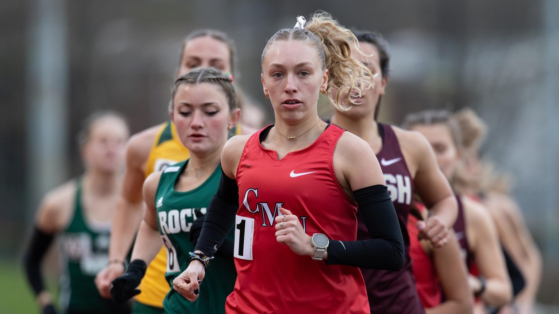 women track runners with leader of a pack wearing a red top